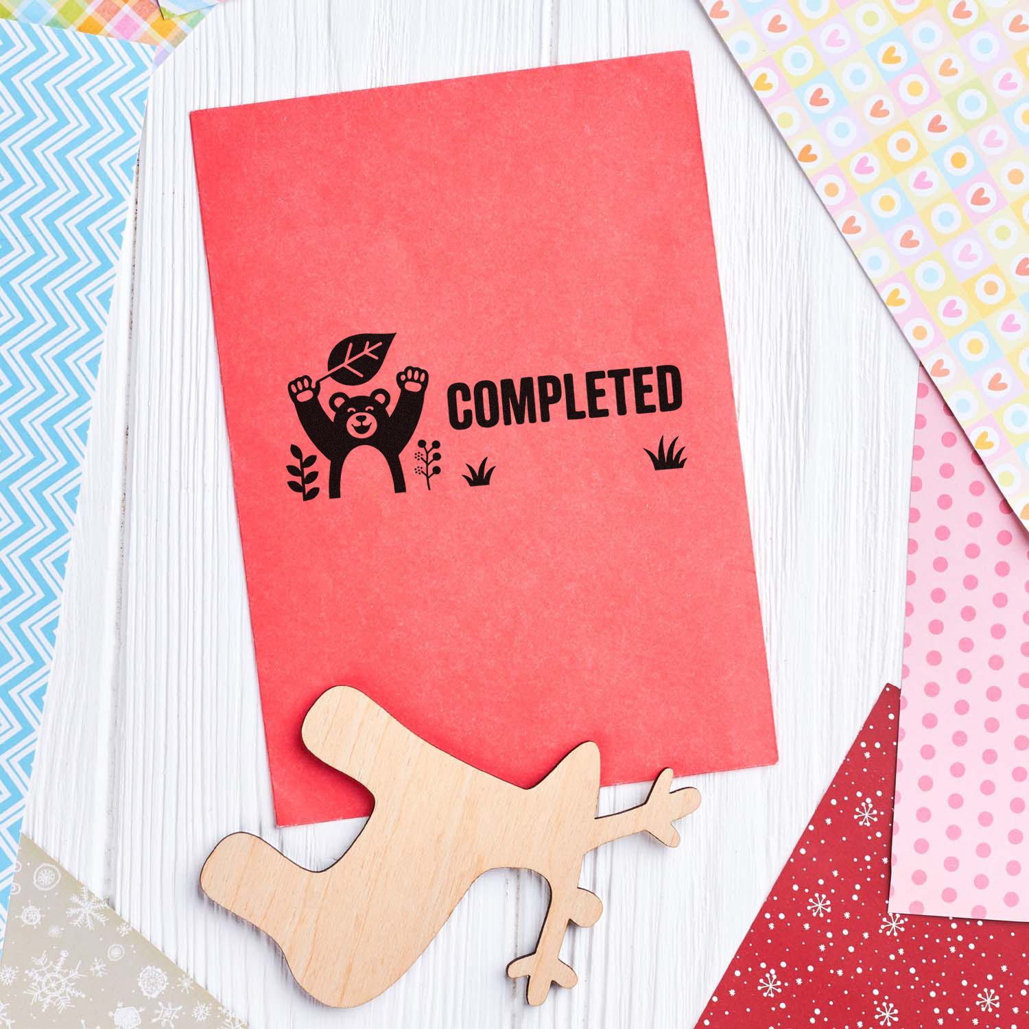 Completed bear rubber stamp on red paper with wood block, ideal for handmade cards, scrapbooking, and craft packaging.