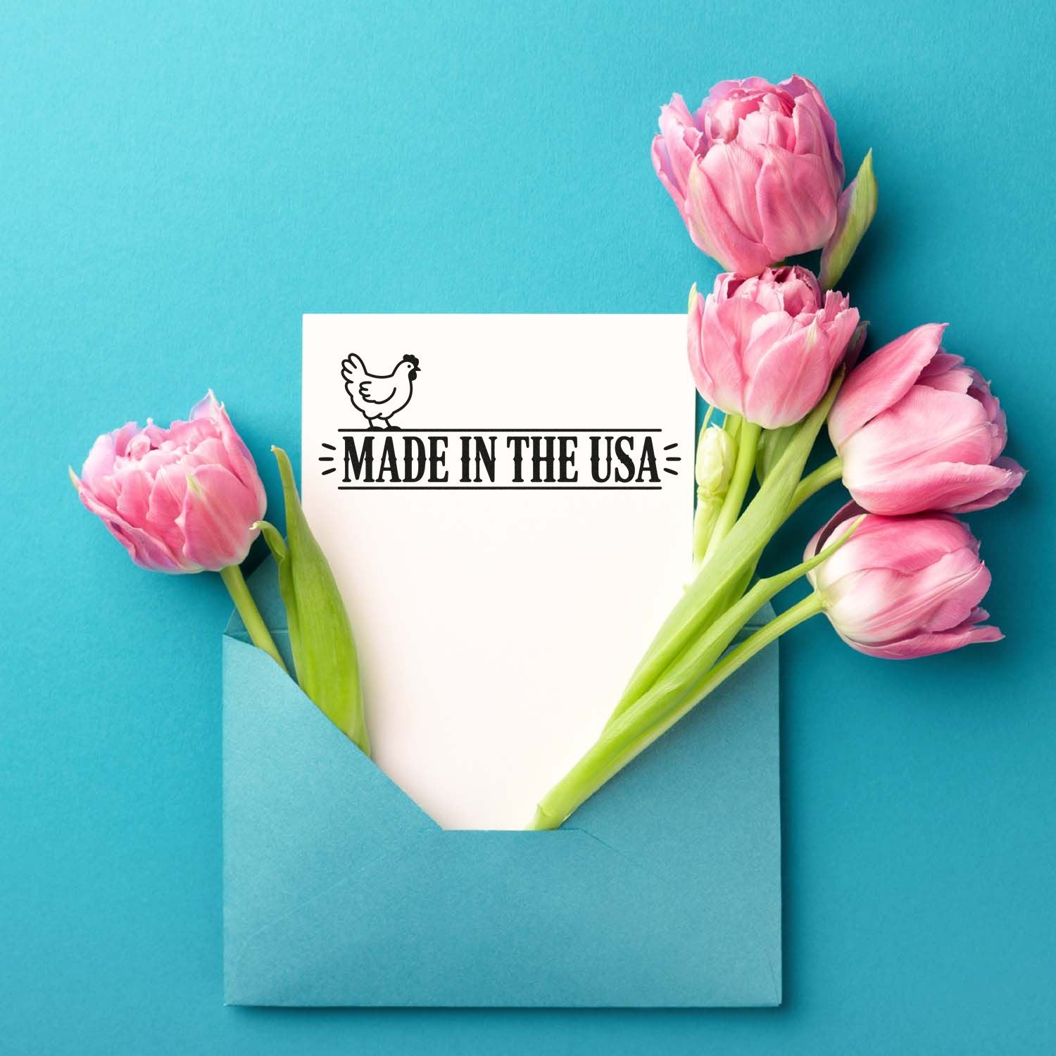 Made in the USA rubber stamp on a floral card with pink tulips in a blue envelope for handmade packaging and patriotic branding.