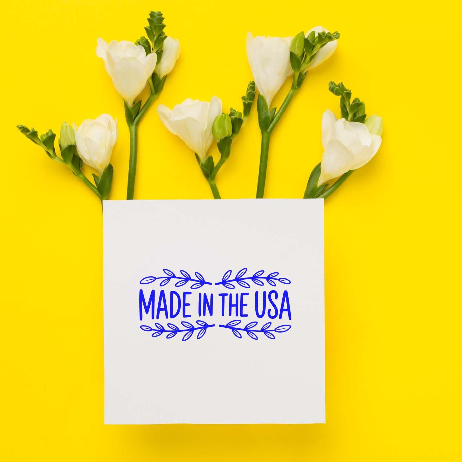 Made in the USA rubber stamp impression on white card with flowers, ideal for product branding and packaging.
