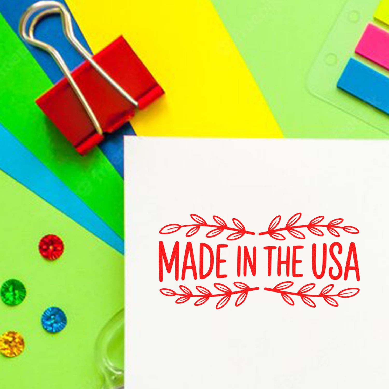 Made in the USA rubber stamp impression on white paper with colorful stationery and clips.