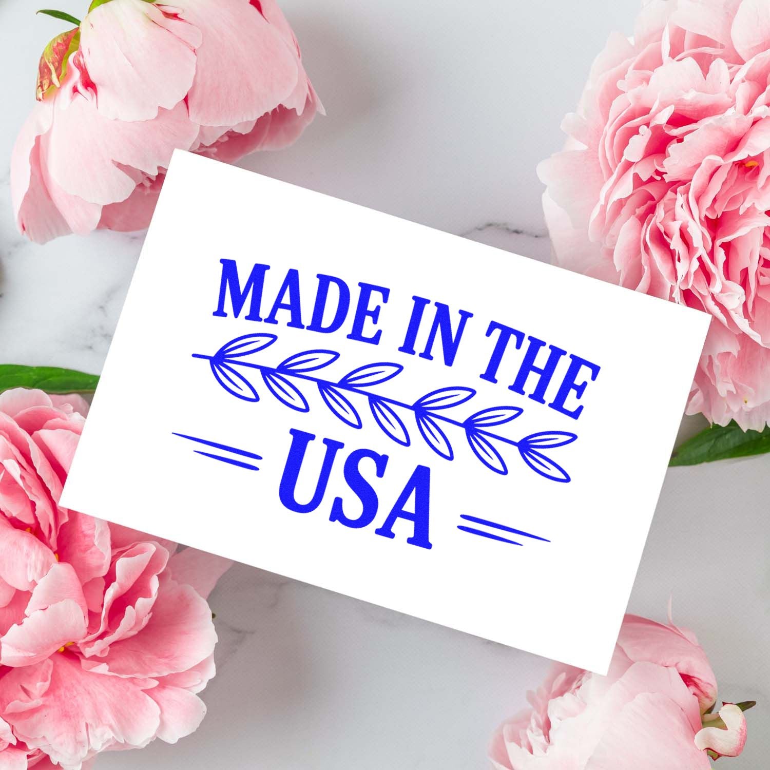 Made in the USA rubber stamp design in blue on white card with pink flowers, ideal for handmade product packaging.