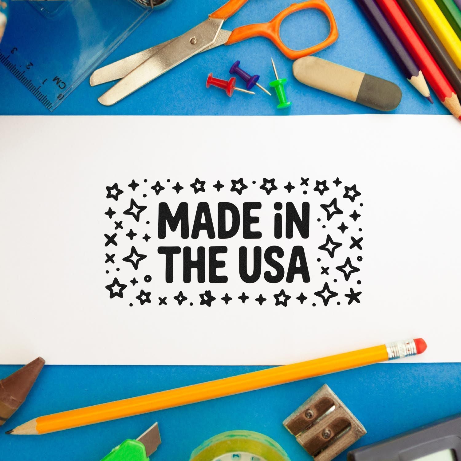 Made in the USA rubber stamp impression on paper, framed by school supplies and craft tools.