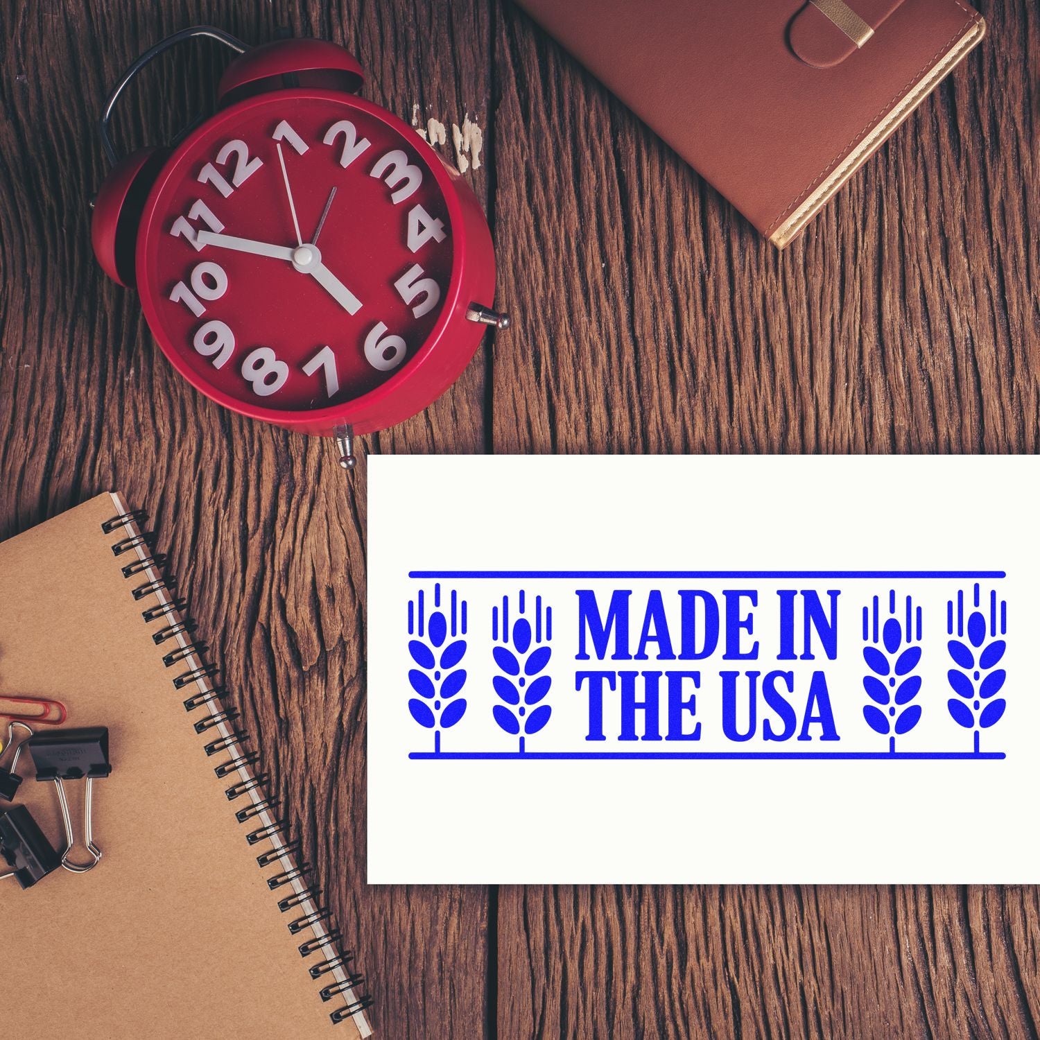 Made in the USA rubber stamp imprint for product packaging and business branding, shown on a wooden desk with office supplies.