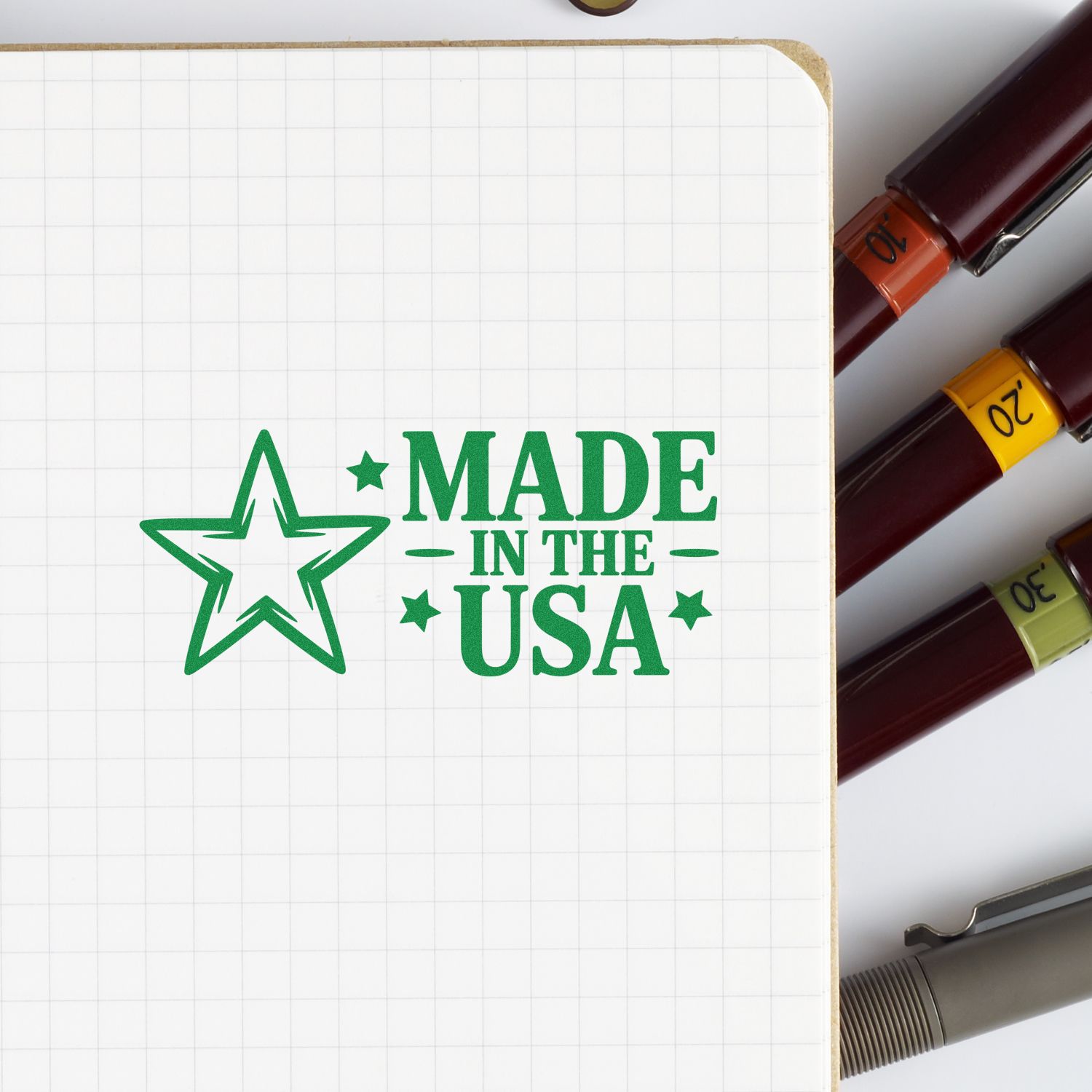 Made in the USA rubber stamp design in green on grid notebook, with color-coded markers showing custom stamp options.