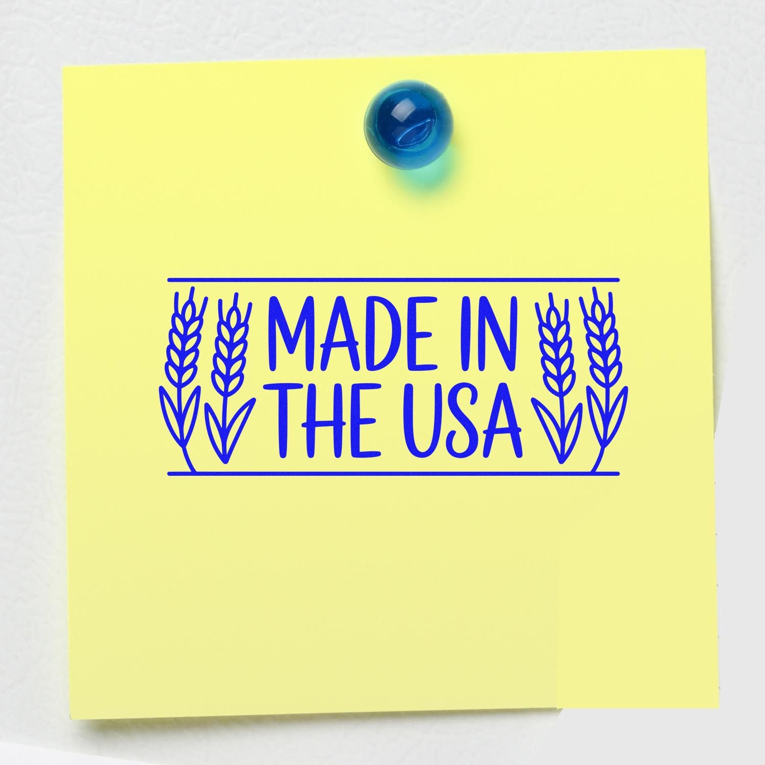Made in the USA rubber stamp design with wheat border, stamped in blue on a yellow note for product packaging and branding.
