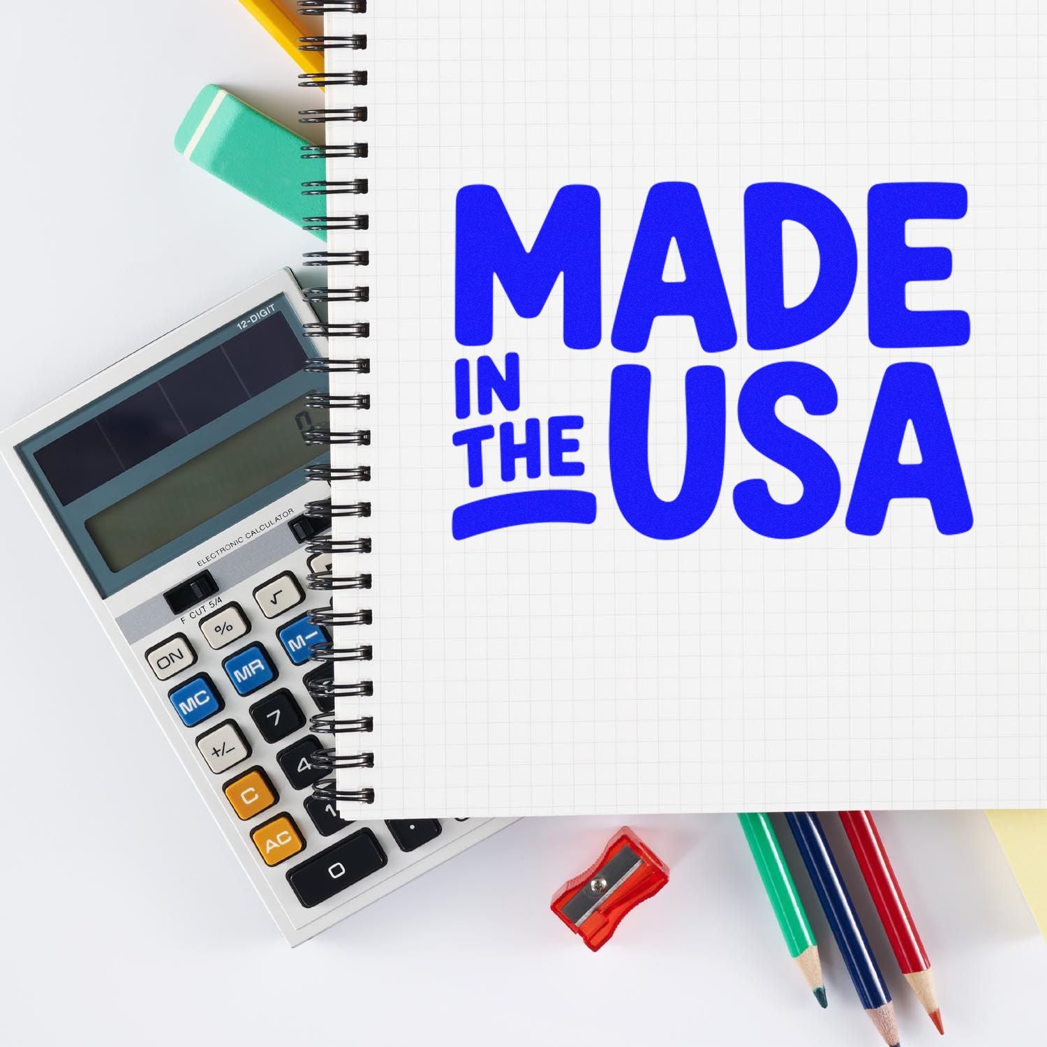 Made in USA rubber stamp design for custom branding, shown on a notebook with calculator, pencils, and sharpener.