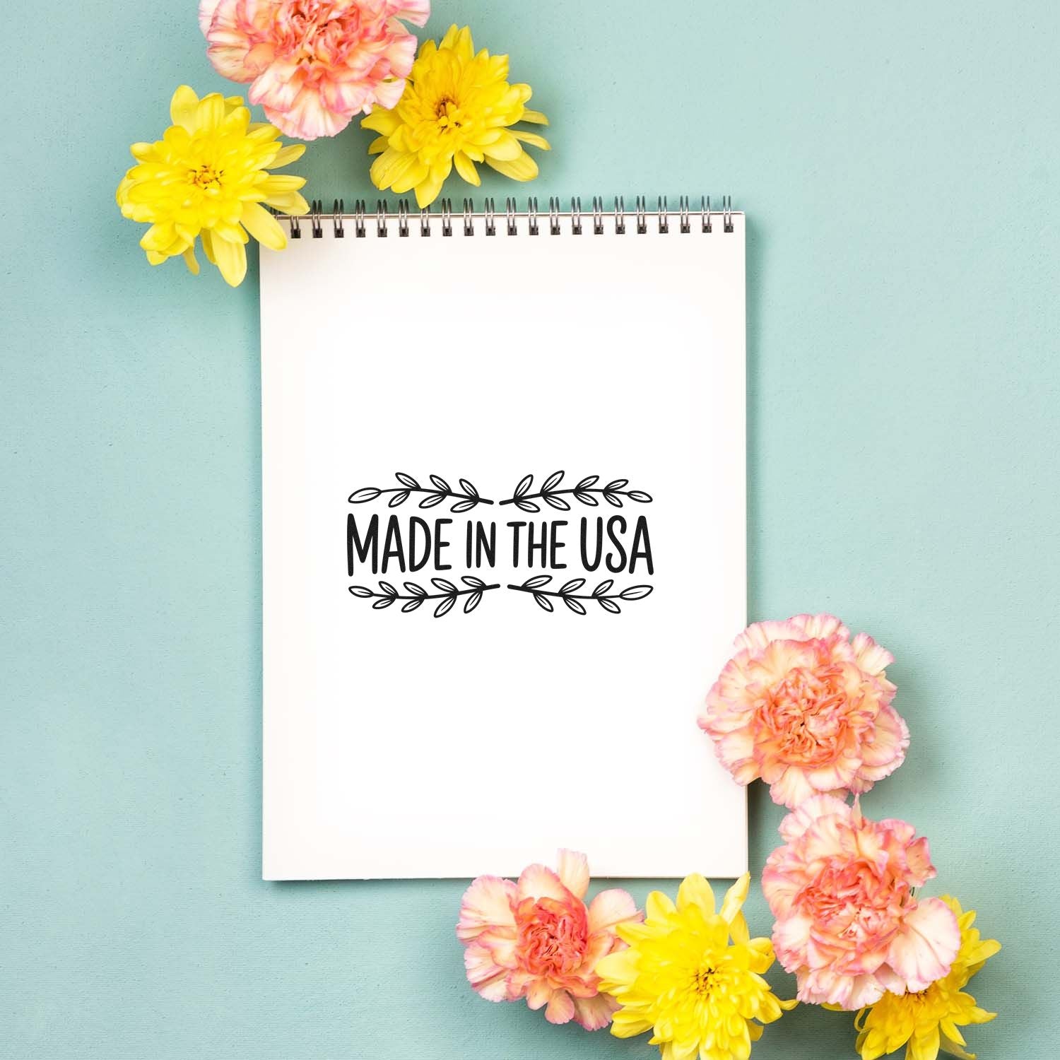 Made in the USA rubber stamp design on a notebook, surrounded by flowers, ideal for patriotic handmade product branding.