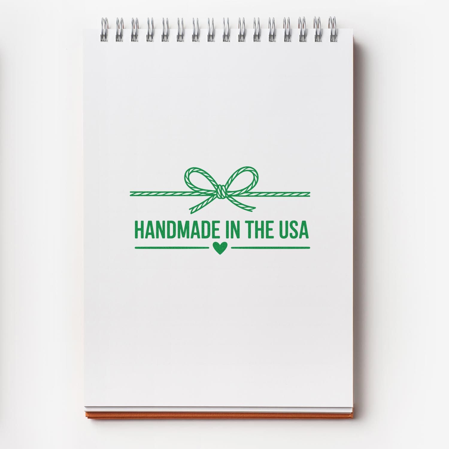 Handmade in the USA rubber stamp design with green bow and heart, ideal for custom packaging, crafts, and product branding.