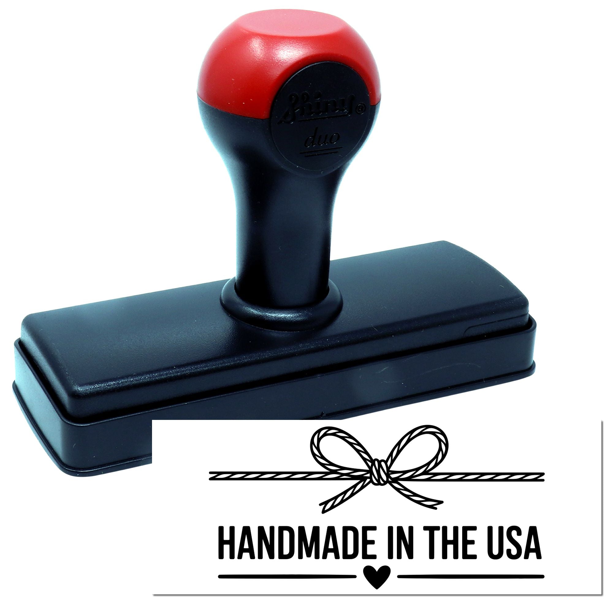 Handmade in the USA rubber stamp with bow design, shown on a self-inking stamp for product packaging.