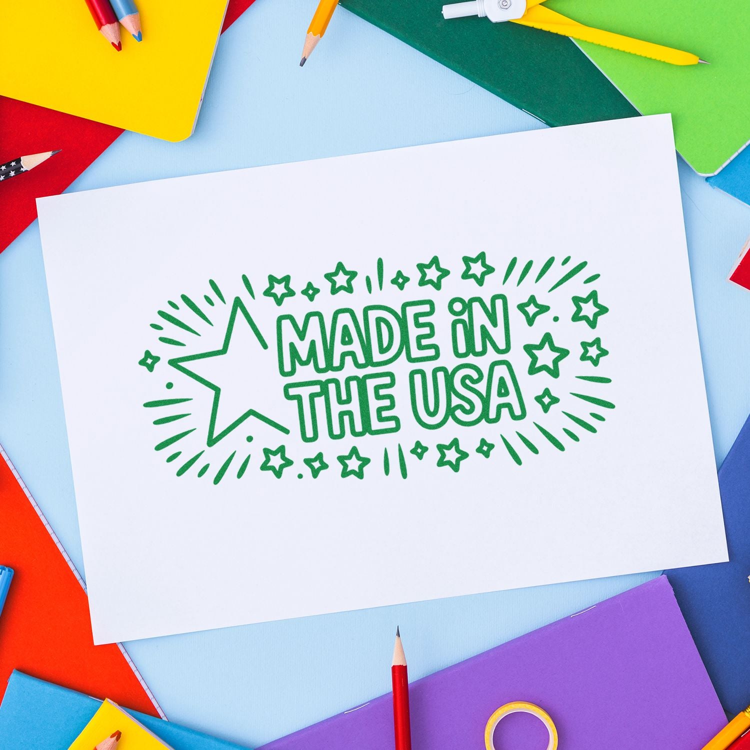 Made in USA rubber stamp impression on white paper, framed by colorful school supplies for crafts, packaging, and labeling.
