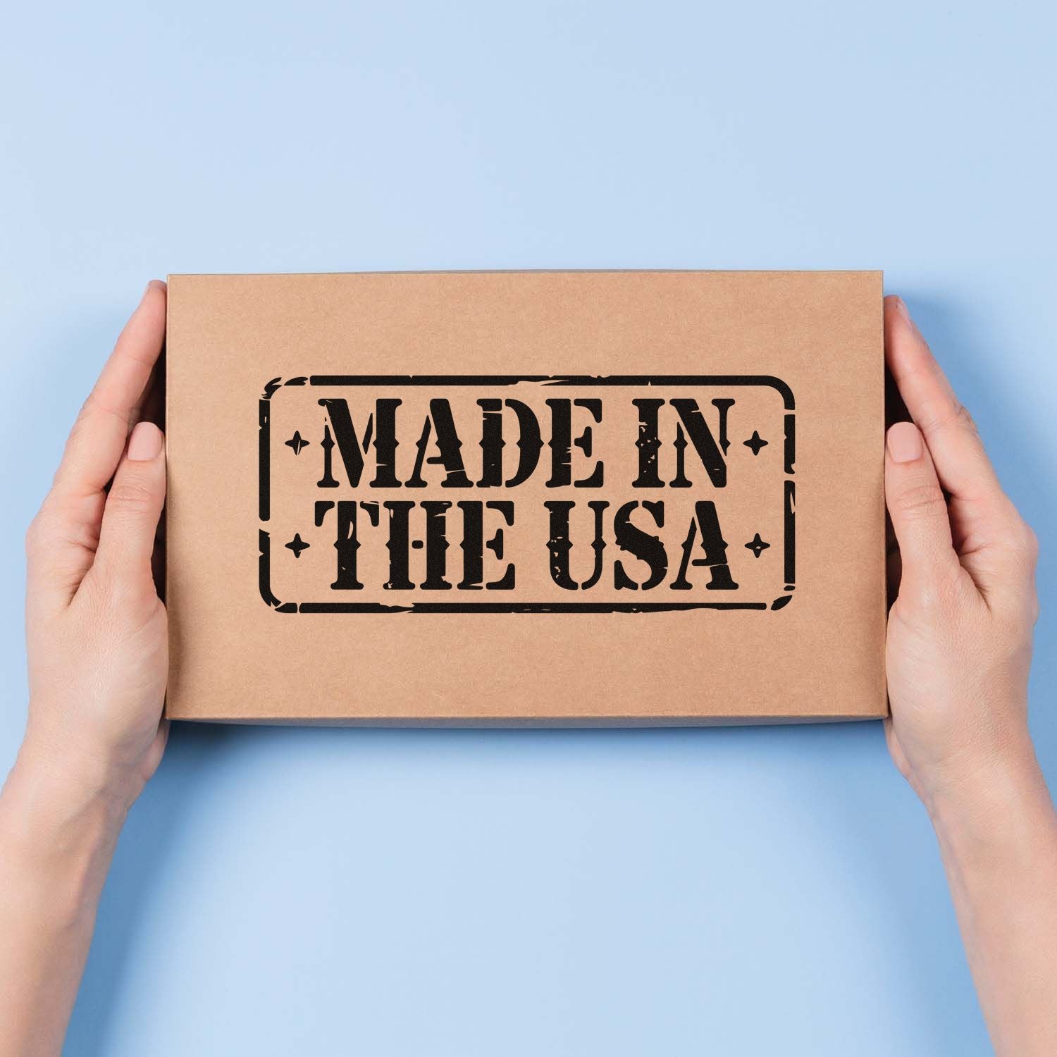 Made in USA rubber stamp on kraft shipping box held in hands, ideal for custom branded packaging.