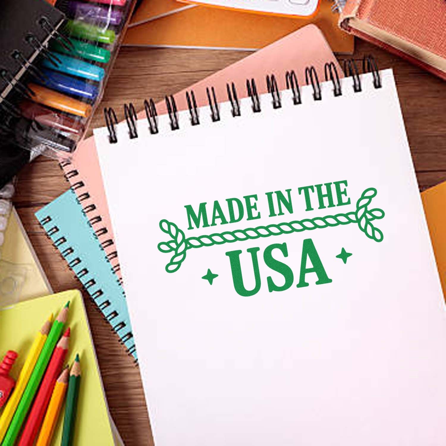 Made in the USA rubber stamp design on a notebook, surrounded by colorful craft and school supplies.