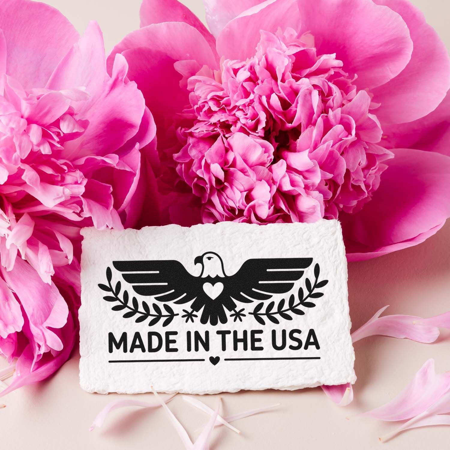 Made in the USA rubber stamp with eagle design, shown on white paper surrounded by pink peonies.
