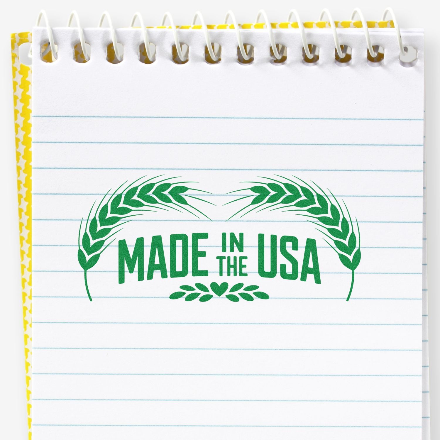 Green Made in the USA rubber stamp on notebook page with laurel wreath design, ideal for product branding and packaging.