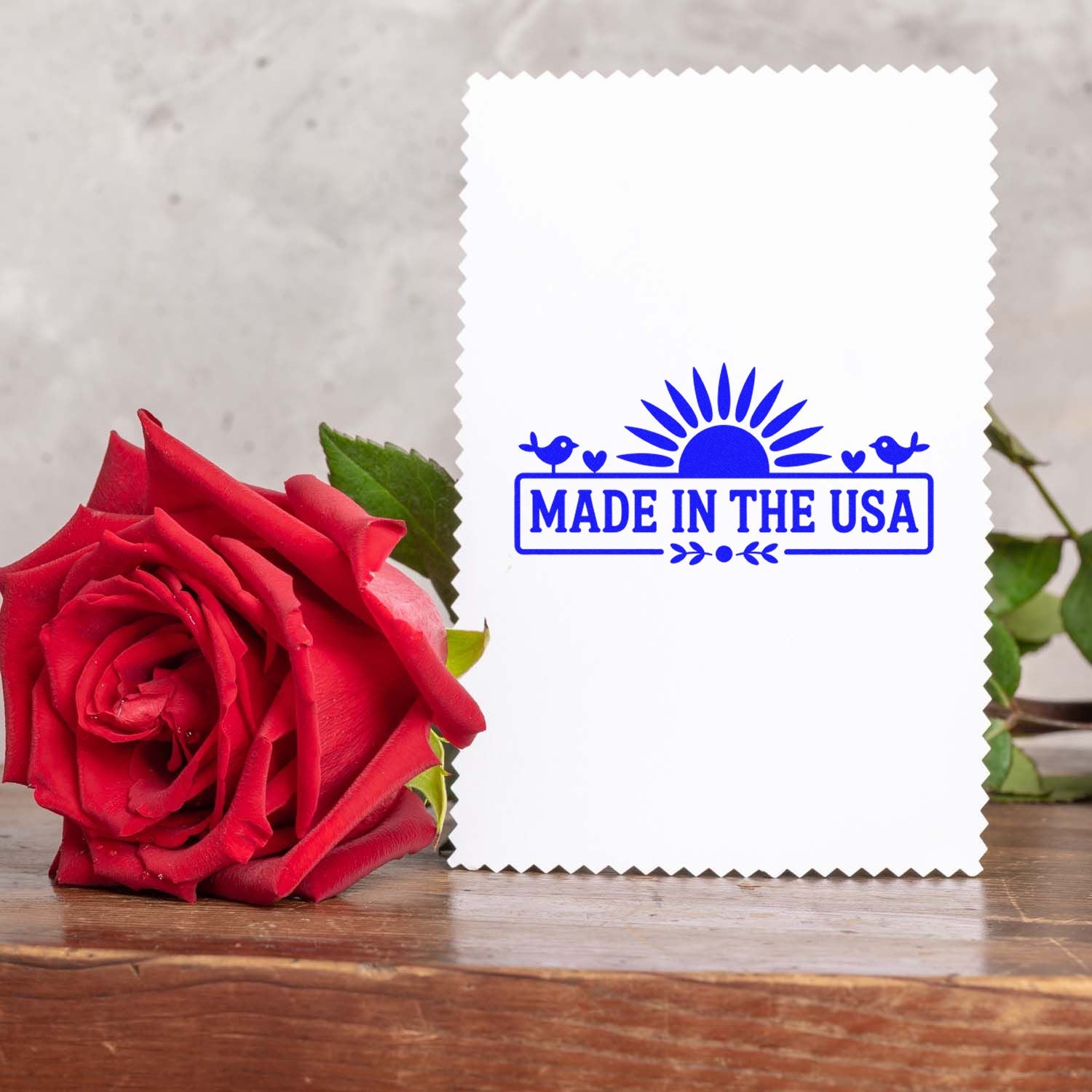 Made in the USA rubber stamp imprint on white card with red rose, ideal for custom packaging and patriotic branding.