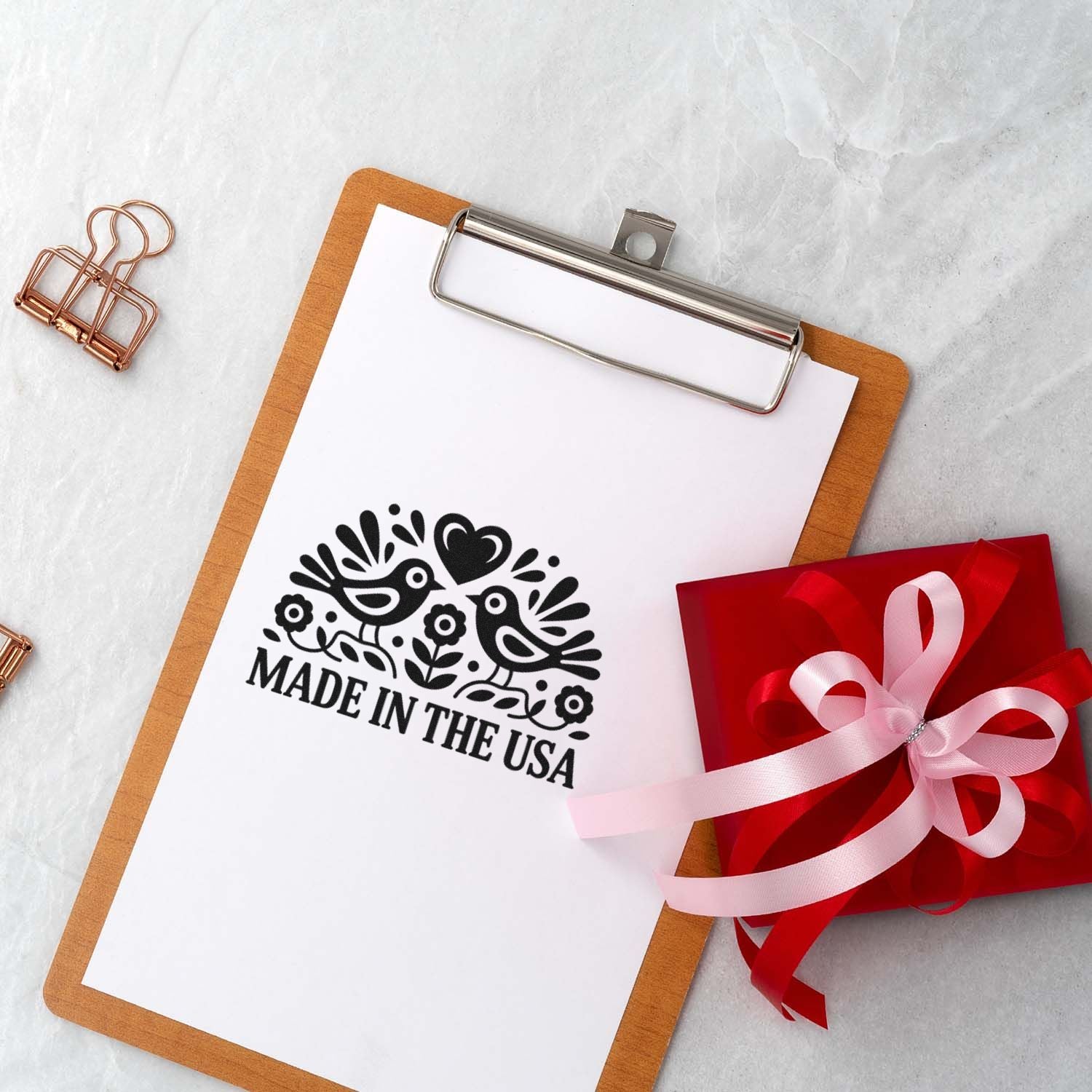 Made in the USA rubber stamp impression on clipboard with gift packaging, perfect for handmade product branding.