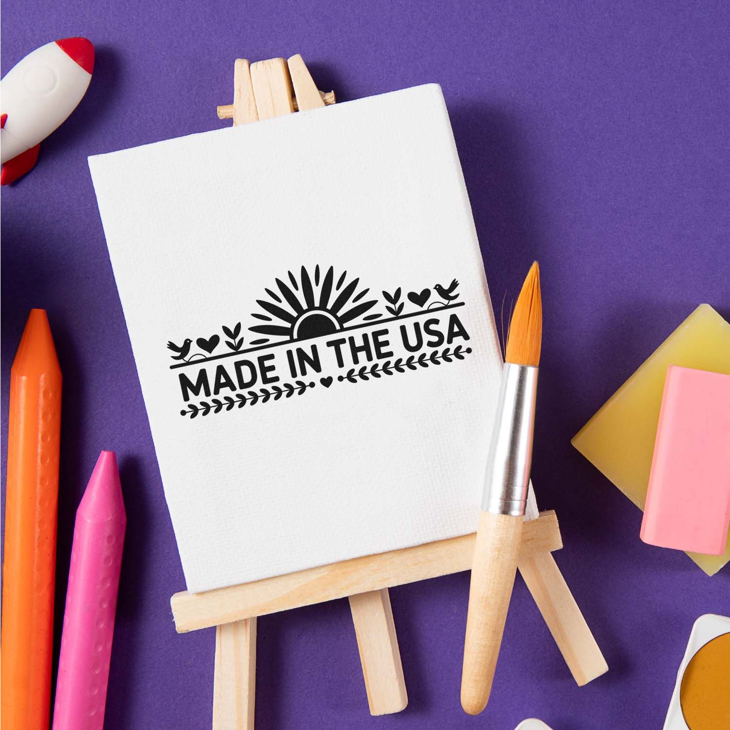 Made in the USA rubber stamp design on a canvas easel with art supplies, perfect for custom branding and craft projects.
