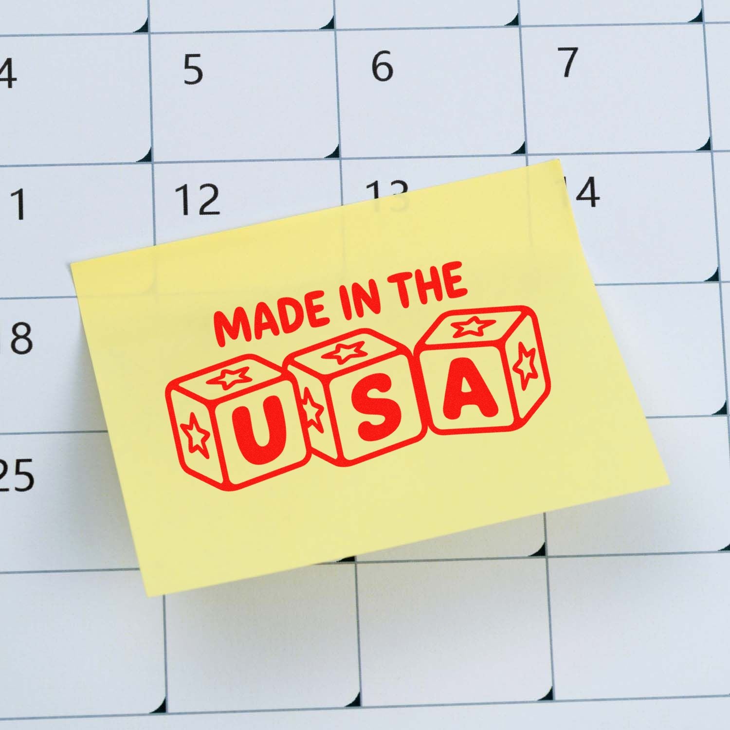 Custom Made in the USA rubber stamp design on a sticky note over a calendar, ideal for product branding and packaging.