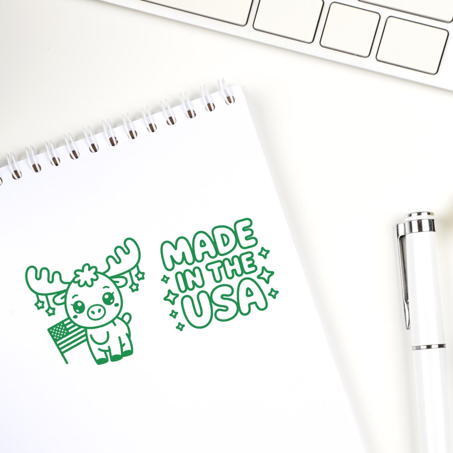 Made in the USA rubber stamp with cute moose and American flag on notebook page, displayed with pen and keyboard