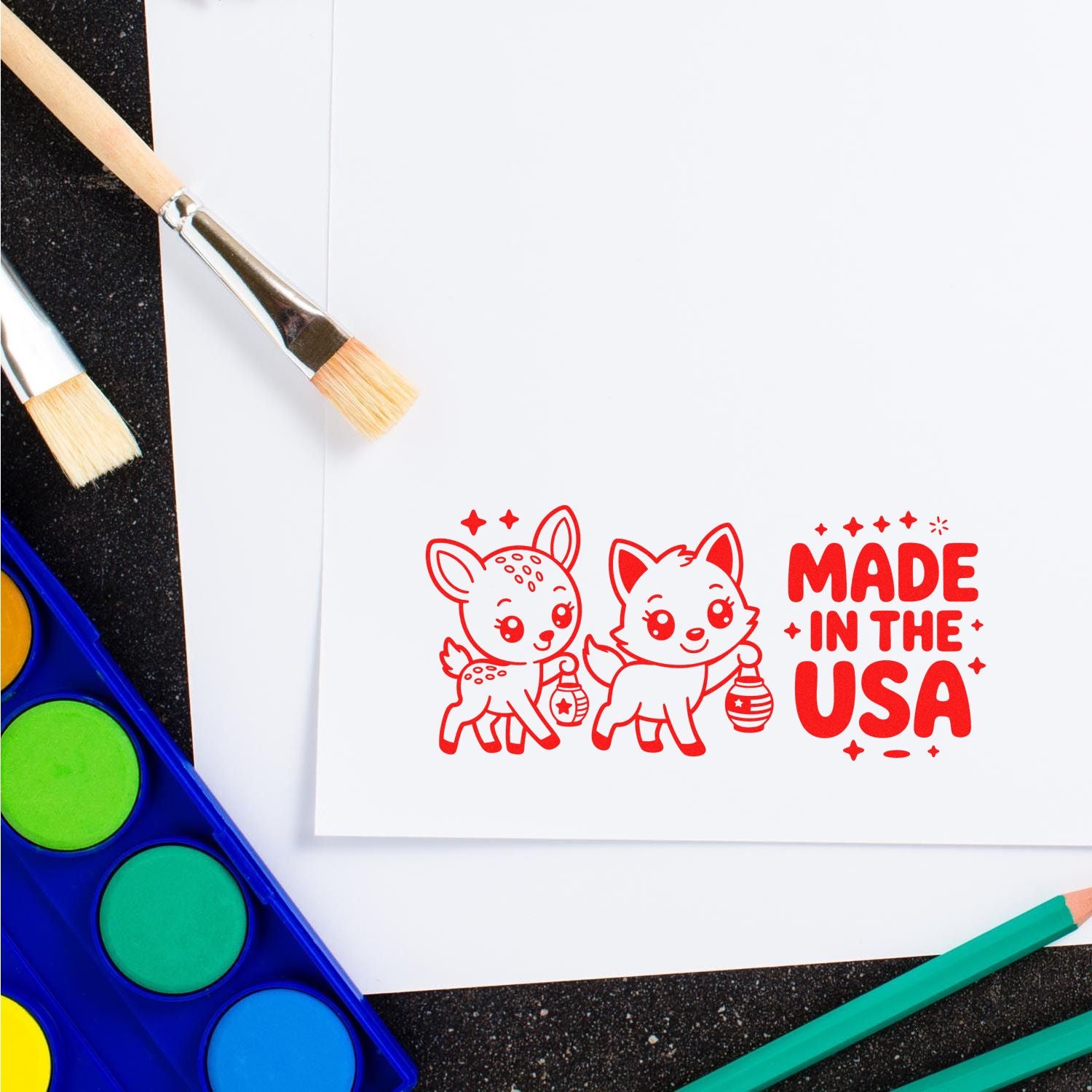 Made in the USA rubber stamp on paper with watercolor brushes and paints for custom craft and branding projects.