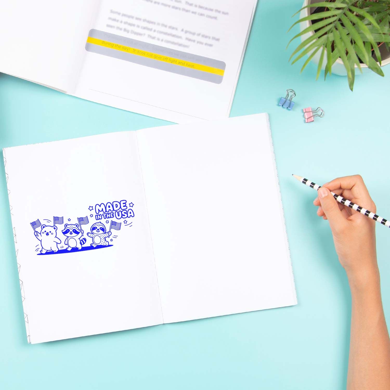 Custom rubber stamp mockup in an open notebook showing a Made in the USA design with cute animals and flags.