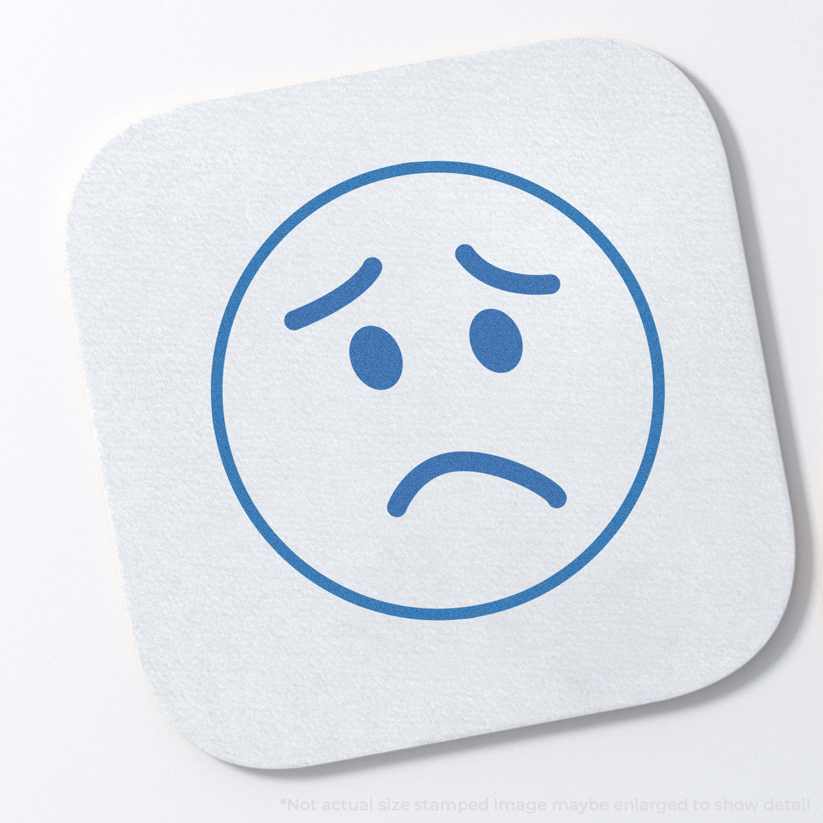 "Frown face" stamp impression on light paper stock, Round Frown Face Stamp