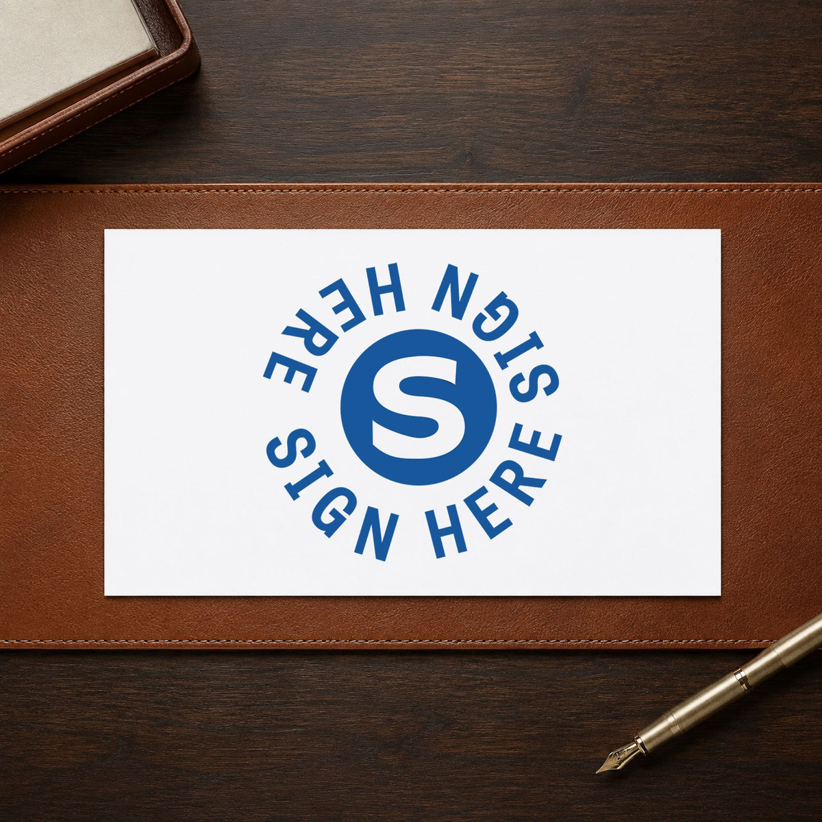 "Sign here" imprint stamped on a document with the Xstamper Sign Here Stamp – Round Blue Pre-Inked