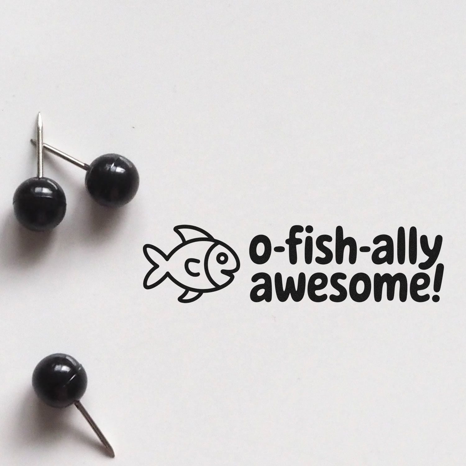 O-fish-ally awesome fish rubber stamp design with push pins on white background, ideal for playful teacher or office use.