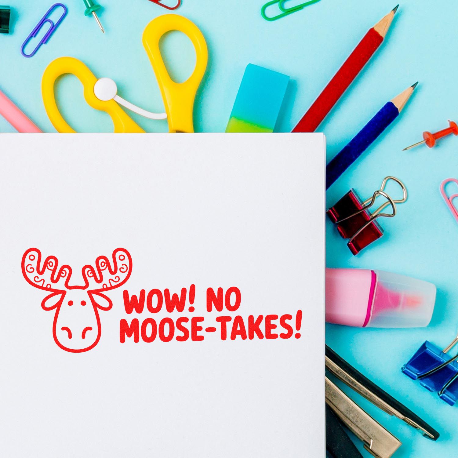 Funny moose rubber stamp design with Wow! No Moose-Takes! on paper, surrounded by colorful school supplies.