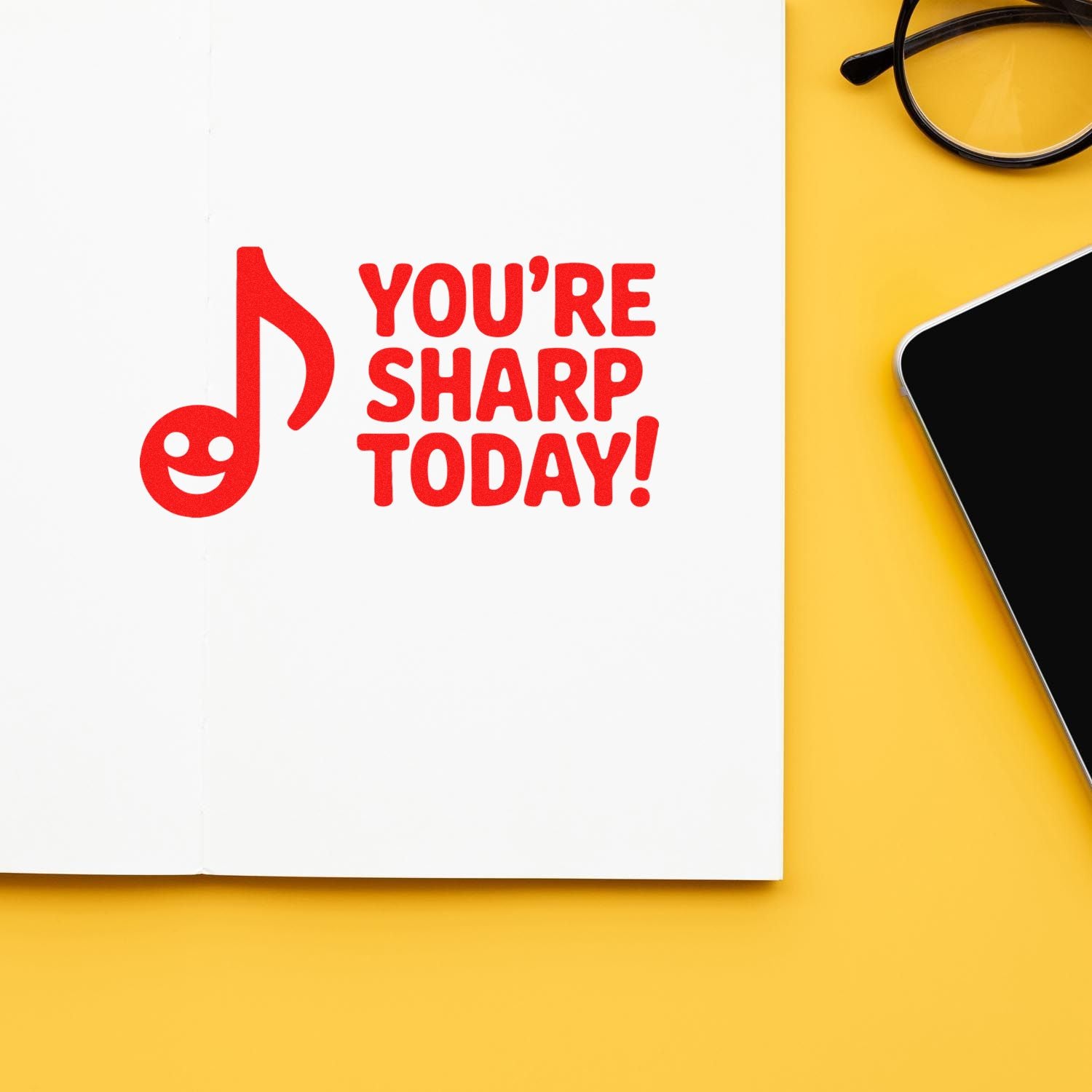 Custom rubber stamp design with Youre Sharp Today! and smiling music note, printed on a notebook page.
