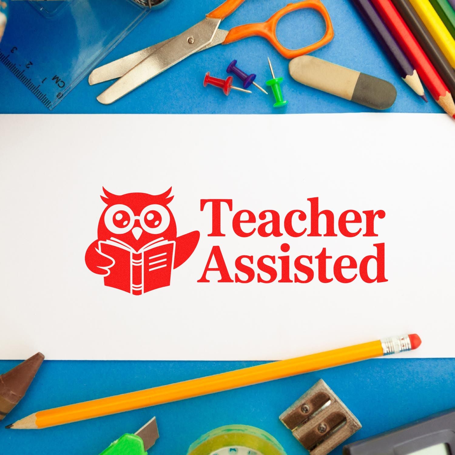 Red Teacher Assisted rubber stamp with owl icon, shown with school supplies for classroom grading and teacher use.