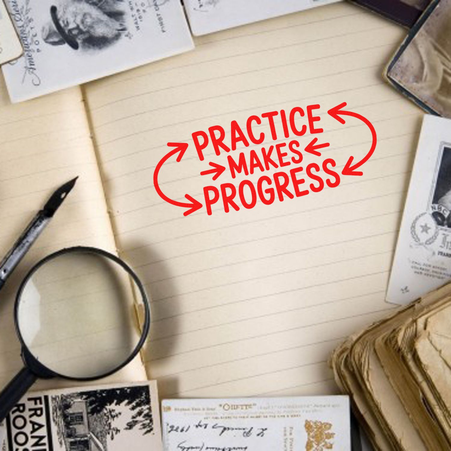 Rubber stamp quote Practice Makes Progress on notebook, styled with vintage stationery and journaling supplies.