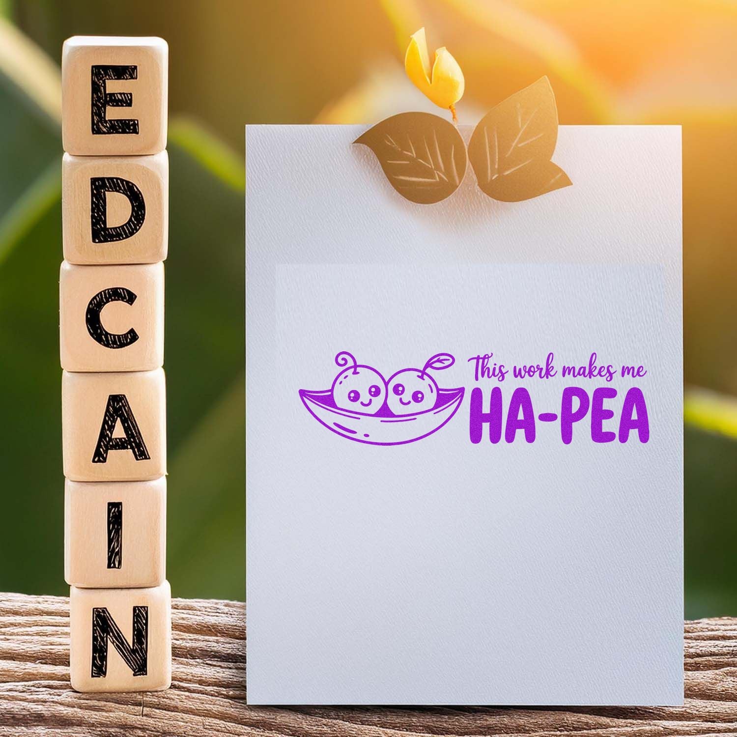 Wooden rubber stamps beside a greeting card with a stamped This work makes me HA-PEA pea design.