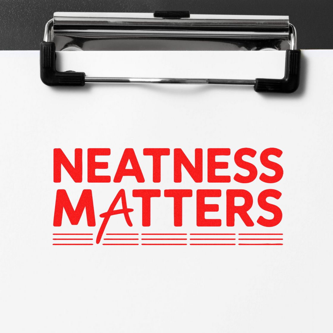 Rubber stamp imprint reading Neatness Matters on paper clipboard for neat, professional document presentation.