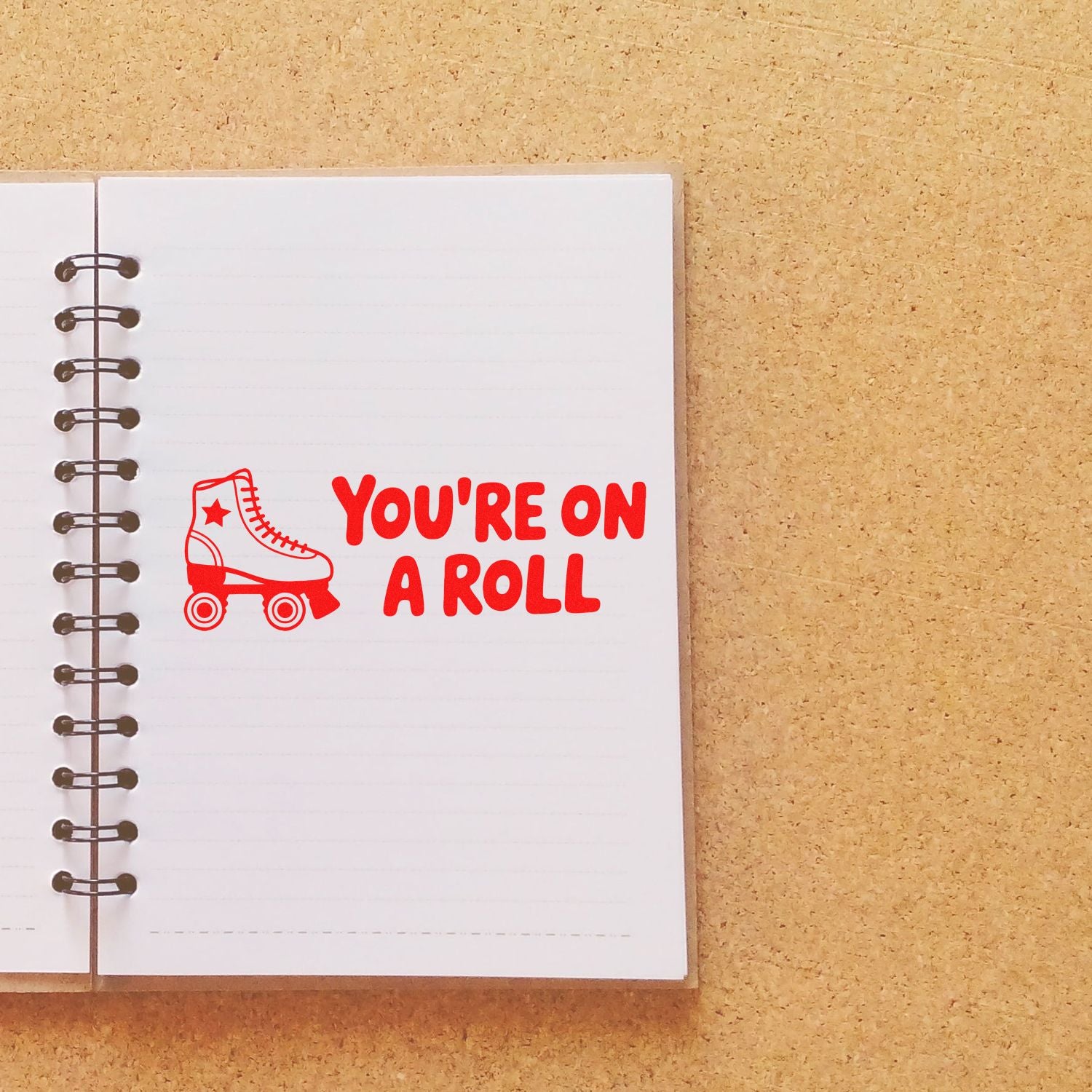 Red roller skate rubber stamp with Youre on a Roll on a notebook page, ideal for motivating planner, journal, or craft projects.