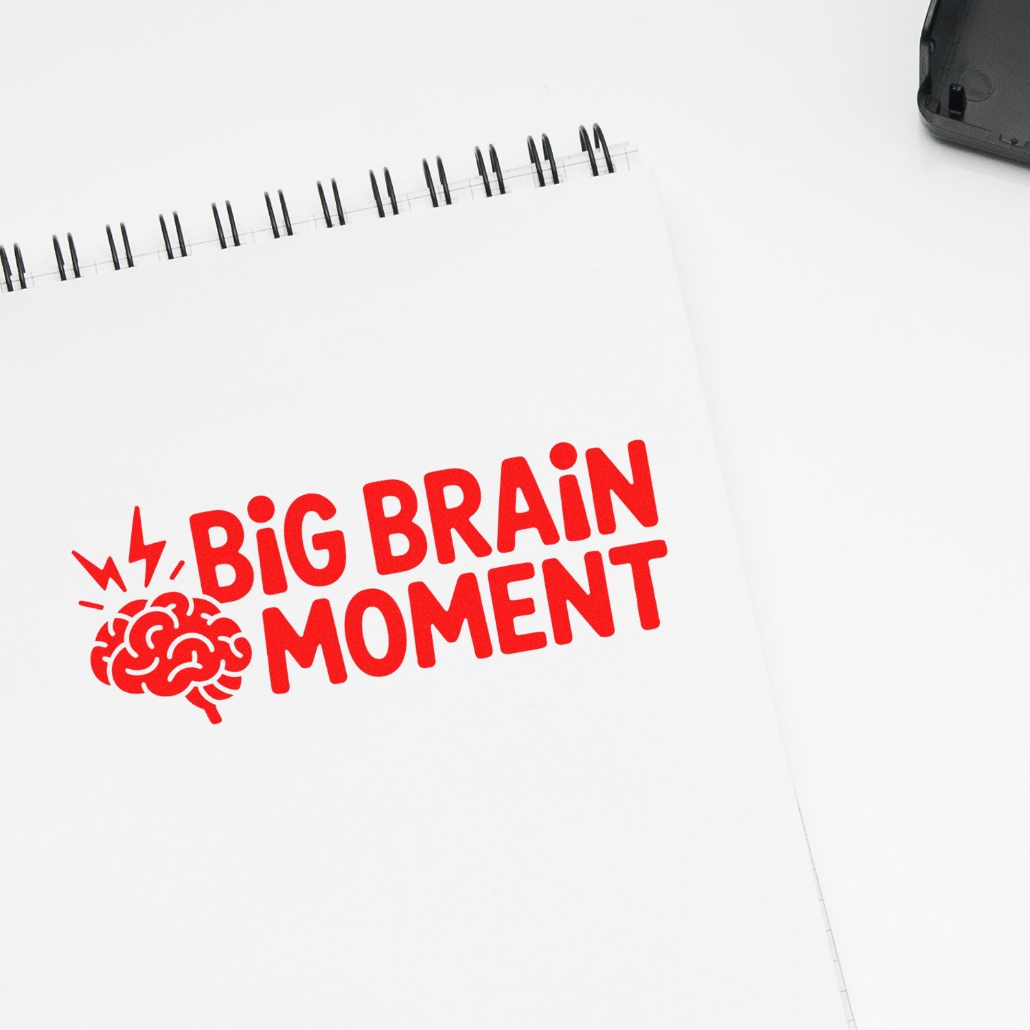 Red Big Brain Moment rubber stamp imprint on a spiral notebook, ideal for playful custom office or classroom stamping.