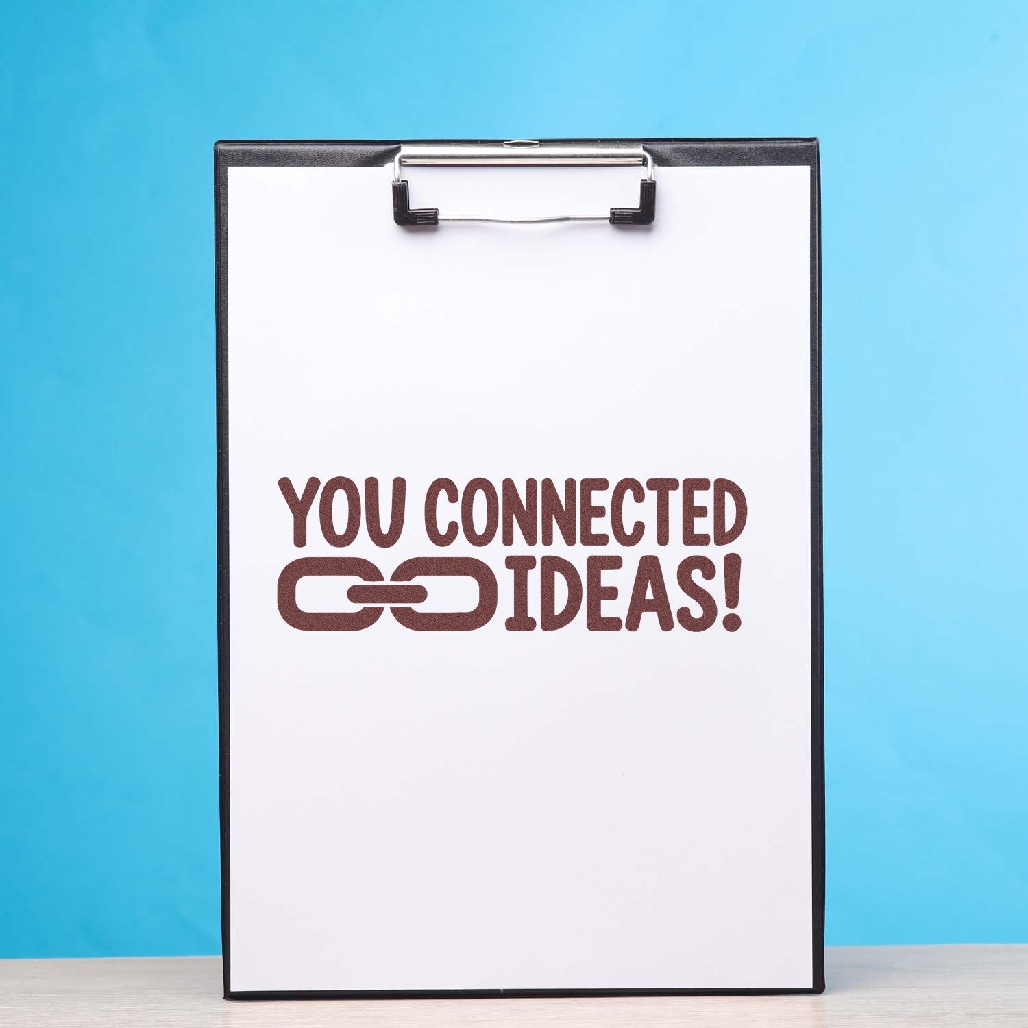 Custom rubber stamp reading You Connected Ideas! on clipboard for creative collaboration and branding.