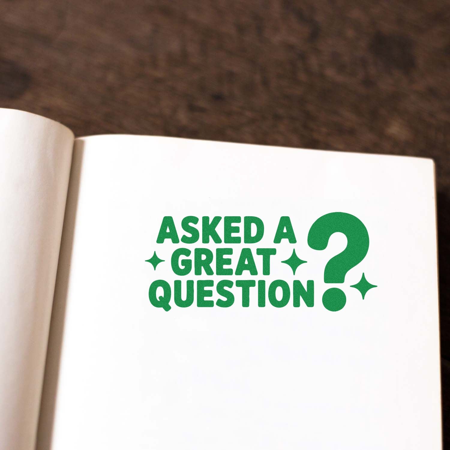 Green rubber stamp reading Asked a Great Question? for teacher feedback, notebooks, and office document marking.