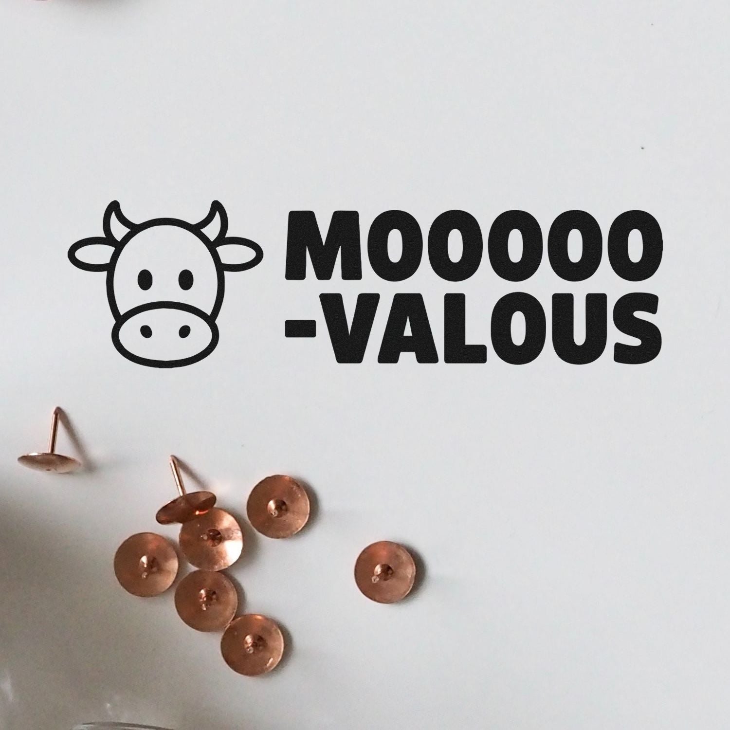 Cow-themed custom rubber stamp design reading MOOO-VALOUS for funny farm, dairy, and greeting card packaging.