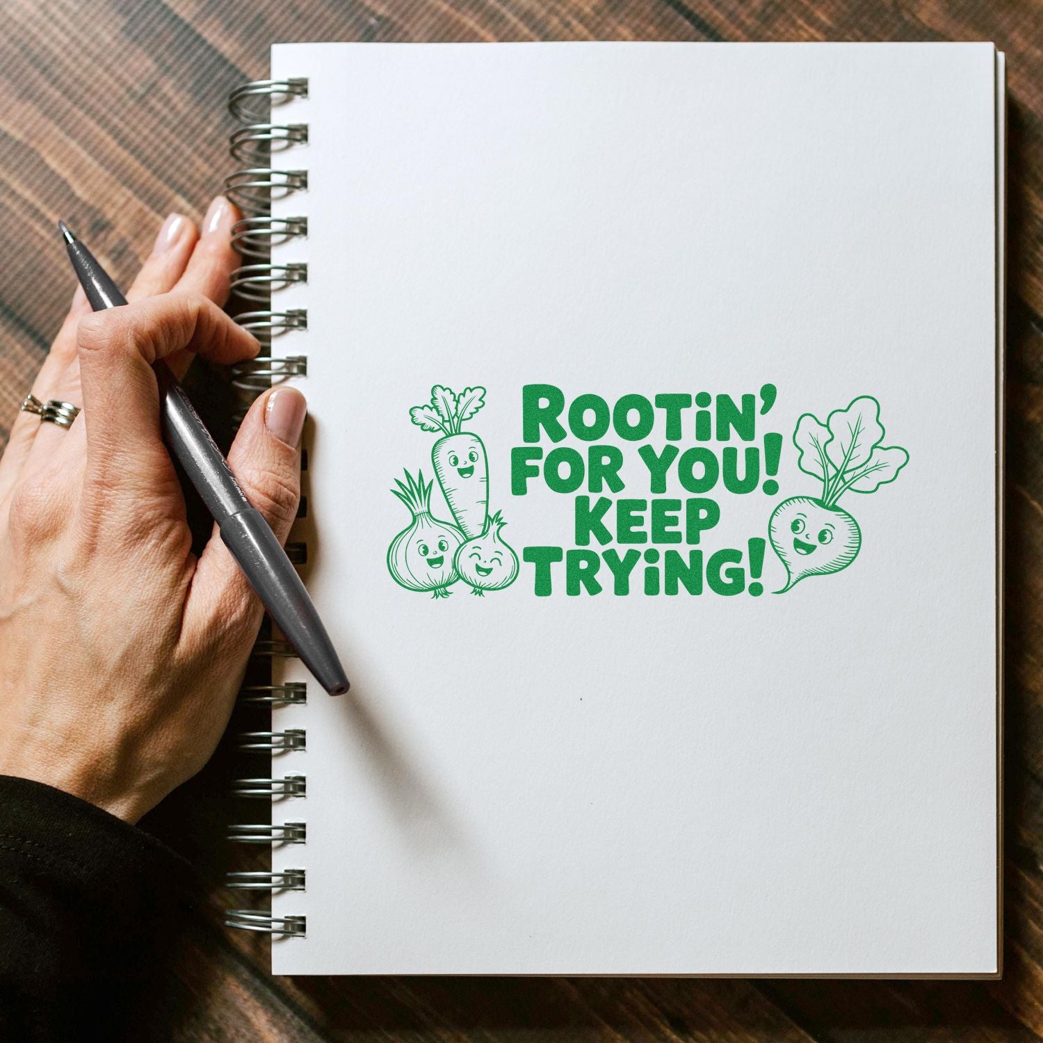 Encouragement rubber stamp design reading Rootin for you! Keep trying! with vegetable characters on a notebook page.