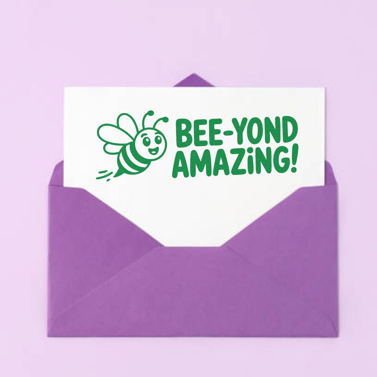 Custom rubber stamp design reading Bee-Yond Amazing with bee graphic on a card in a purple envelope.