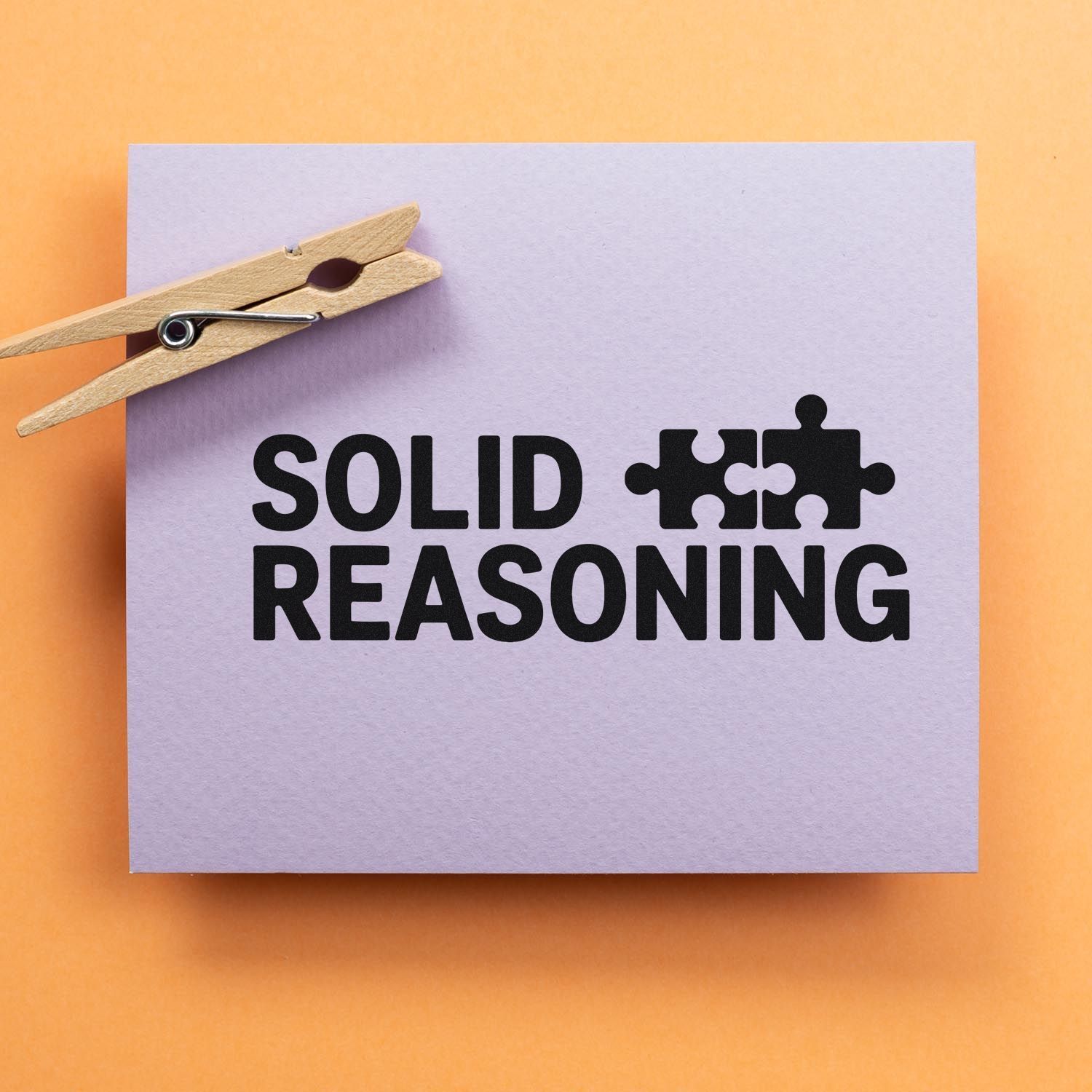 Solid Reasoning rubber stamp design with puzzle-piece icon clipped to paper for classroom or business use.