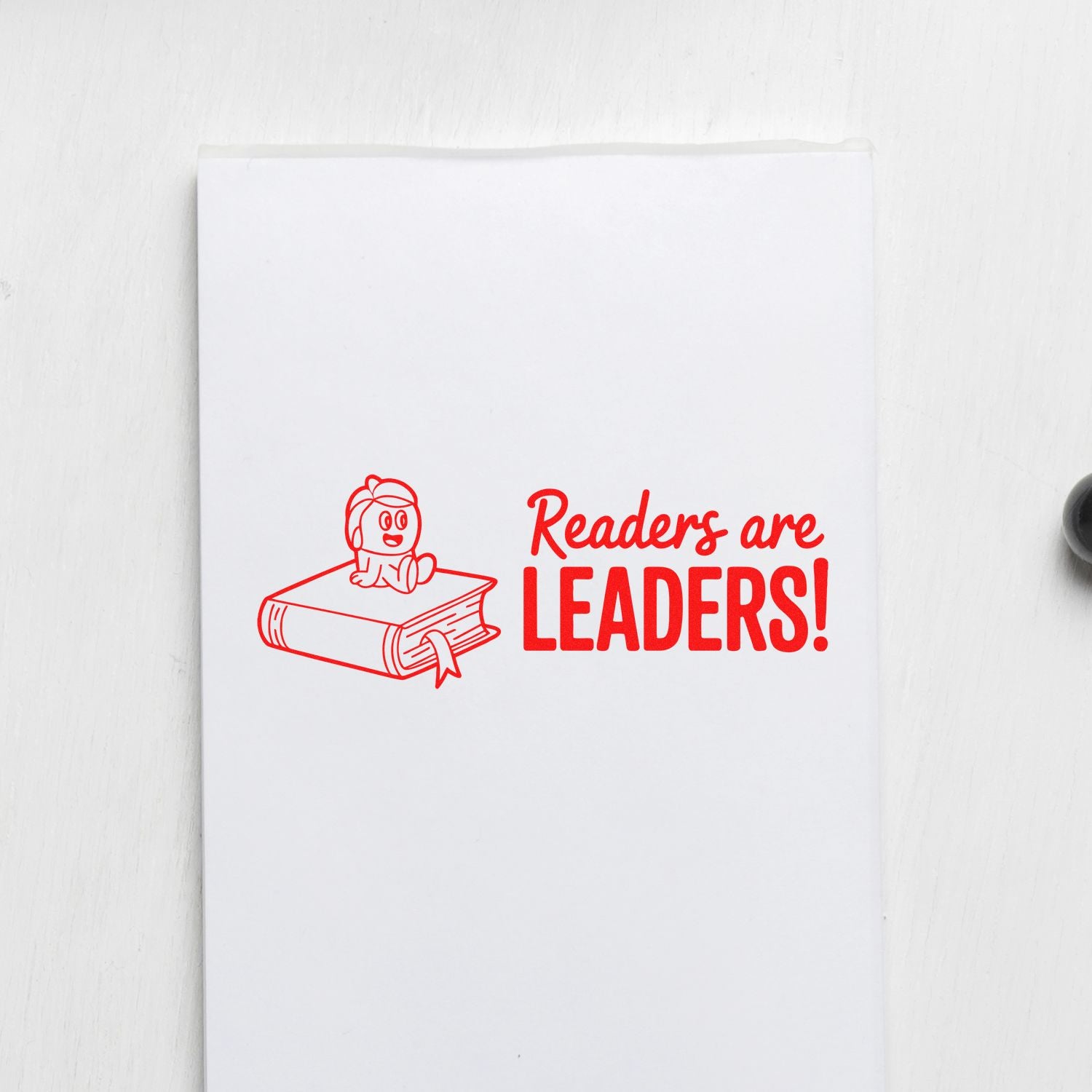 Red rubber stamp design with child on a book and the message Readers are leaders! for teachers and classroom use.
