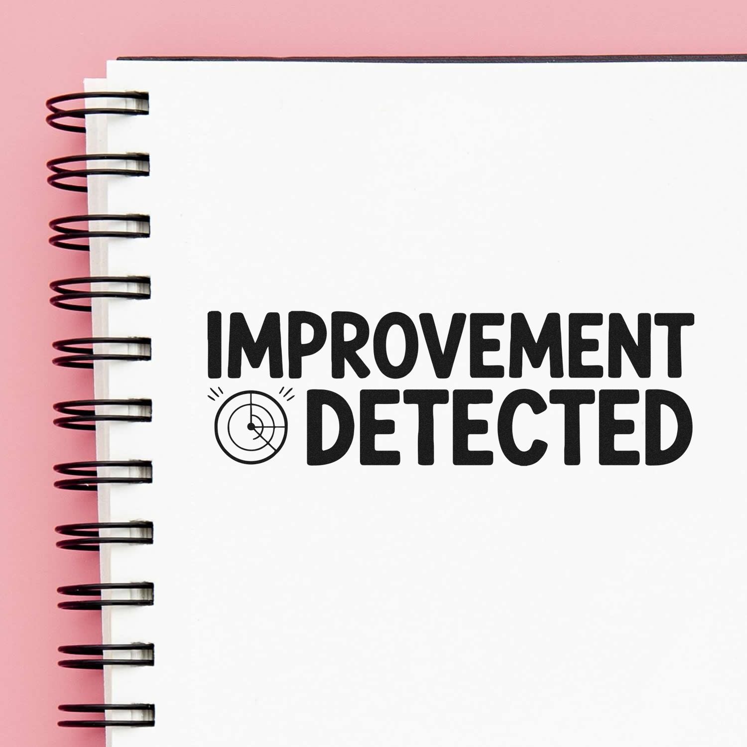 Improvement Detected rubber stamp imprint on notebook page for quality control and business documents.