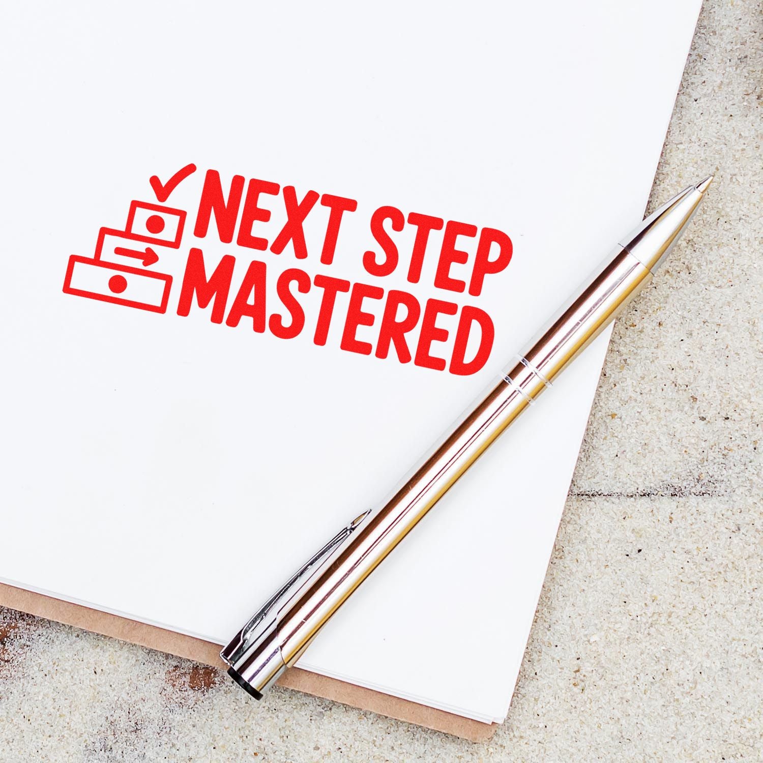 Red Next Step Mastered rubber stamp on white paper with pen, ideal for workflow approval and task completion.