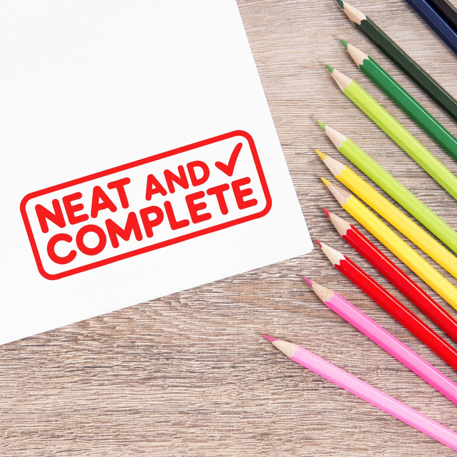 Red Neat and Complete rubber stamp on paper, with colored pencils, for office approval and finished work labeling.