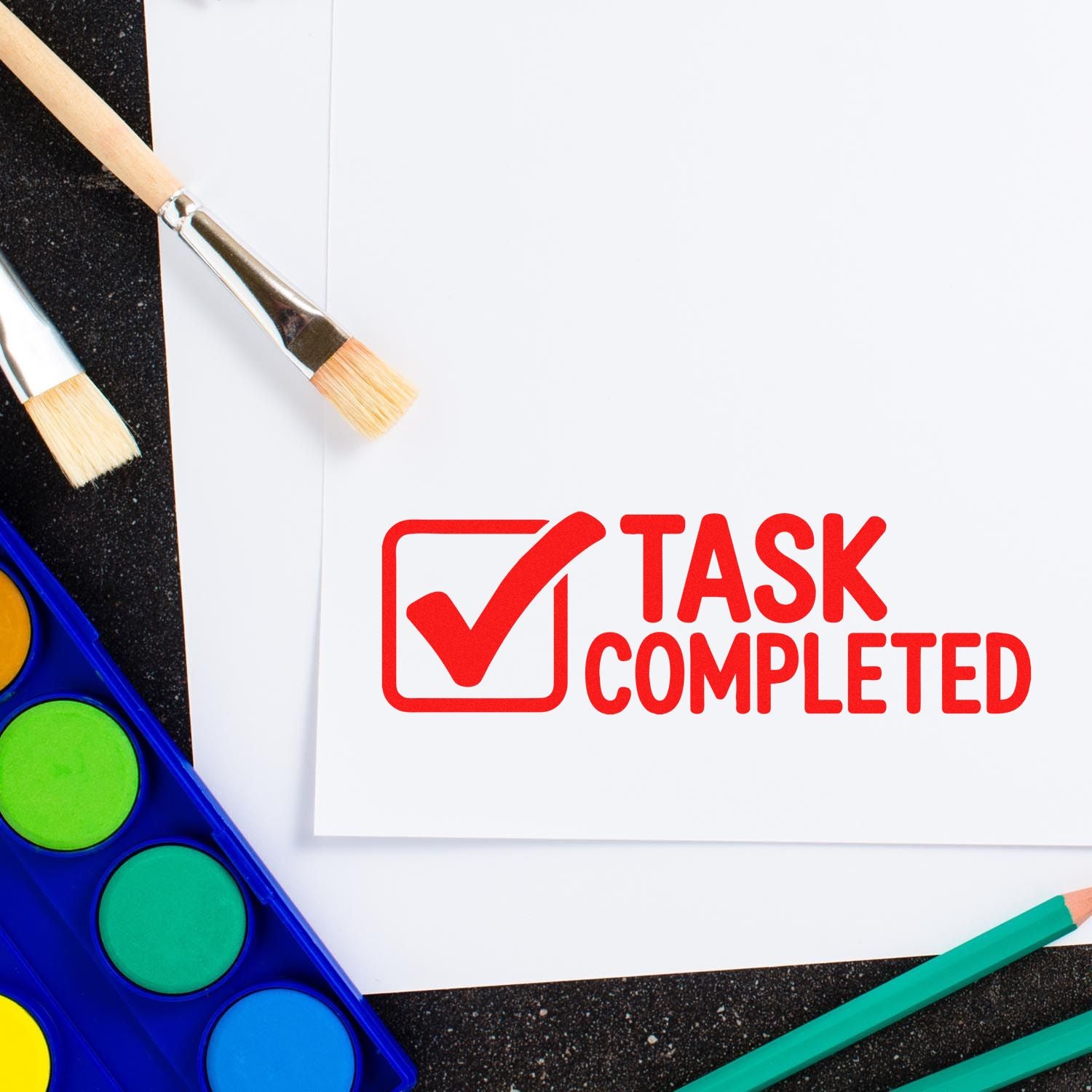 Red task completed rubber stamp on white paper, ideal for marking finished projects and checklist approvals.