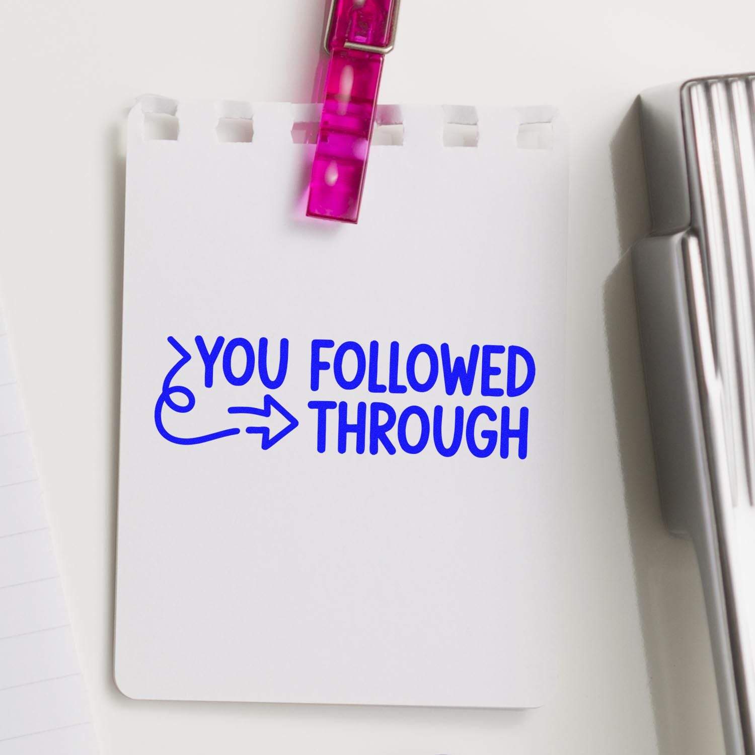 Rubber stamp with blue You Followed Through motivational message on clipped notepad, ideal for teachers and planners.