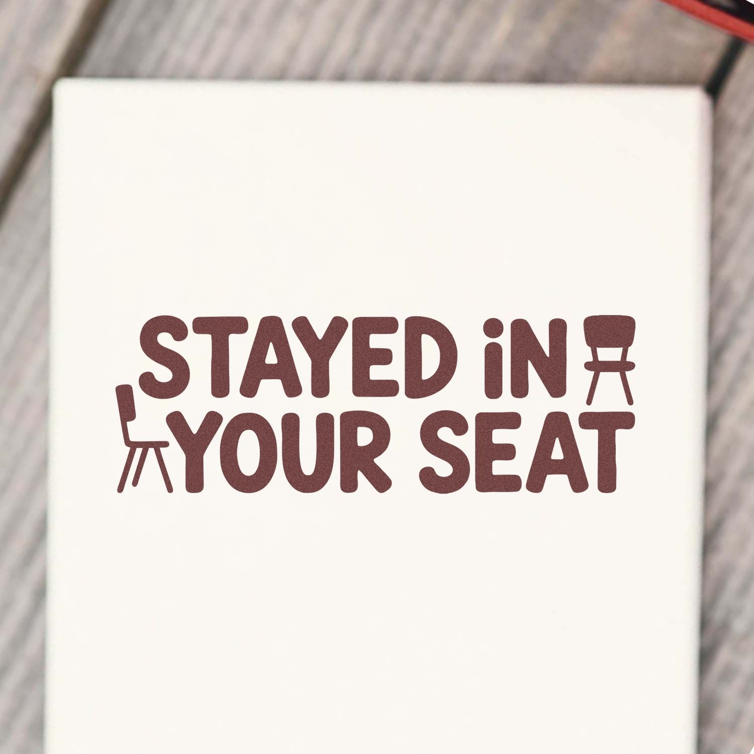 Stayed in Your Seat rubber stamp design for classroom behavior rewards, with bold text and chair icons on white background.