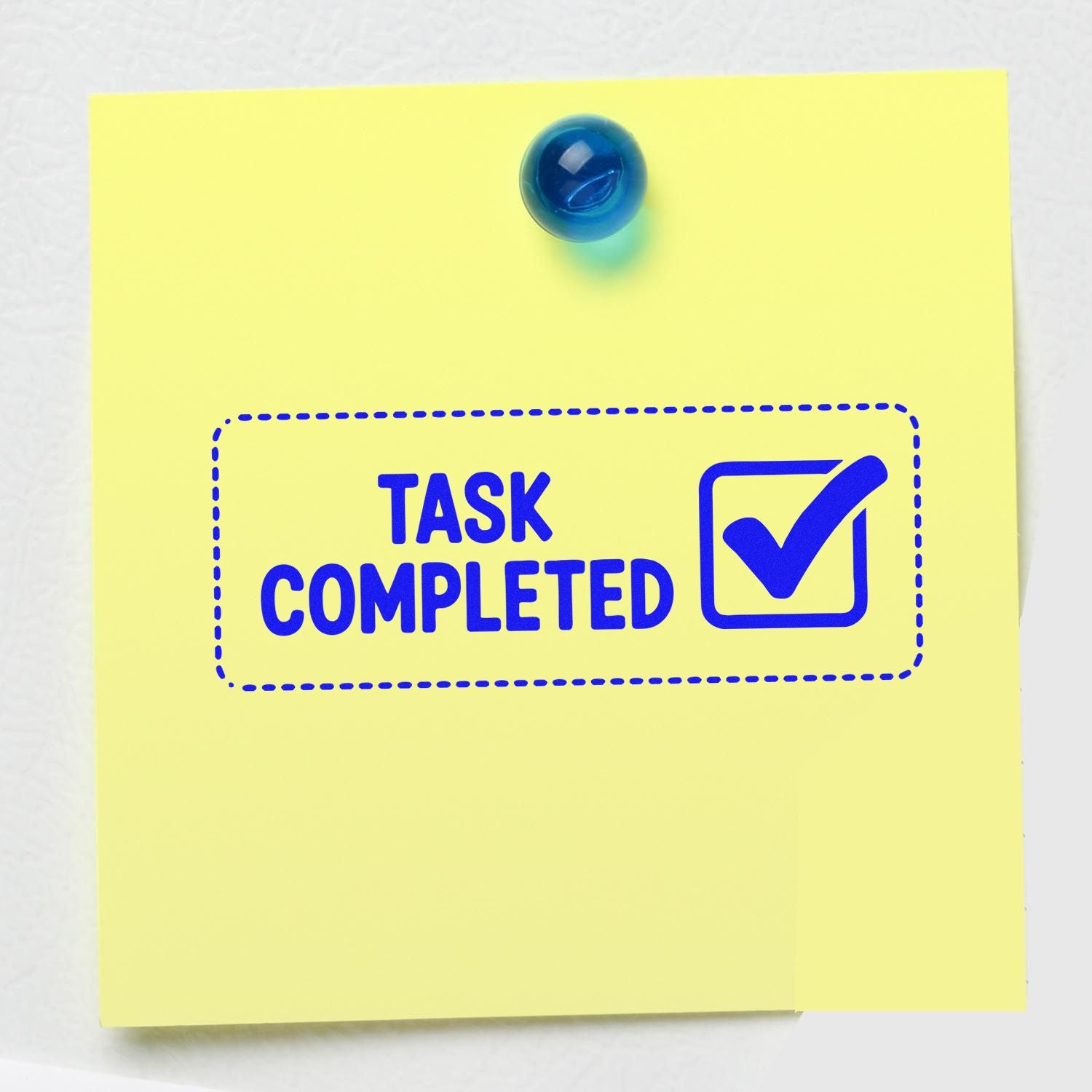 Task completed rubber stamp design on yellow sticky note with blue check mark for office approval and task tracking.